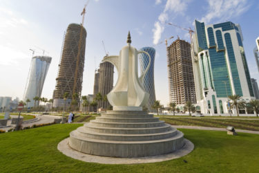 The Dallah coffee pot sculpture on the Corniche in Doha the capital of Qatar, behind it are the new high rise building being built to fill the skyline.