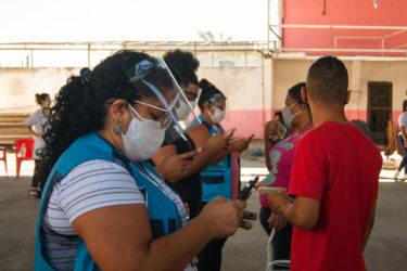 Reporters take down a resident's data in the Jacarezinho favela, Rio de Janeiro.